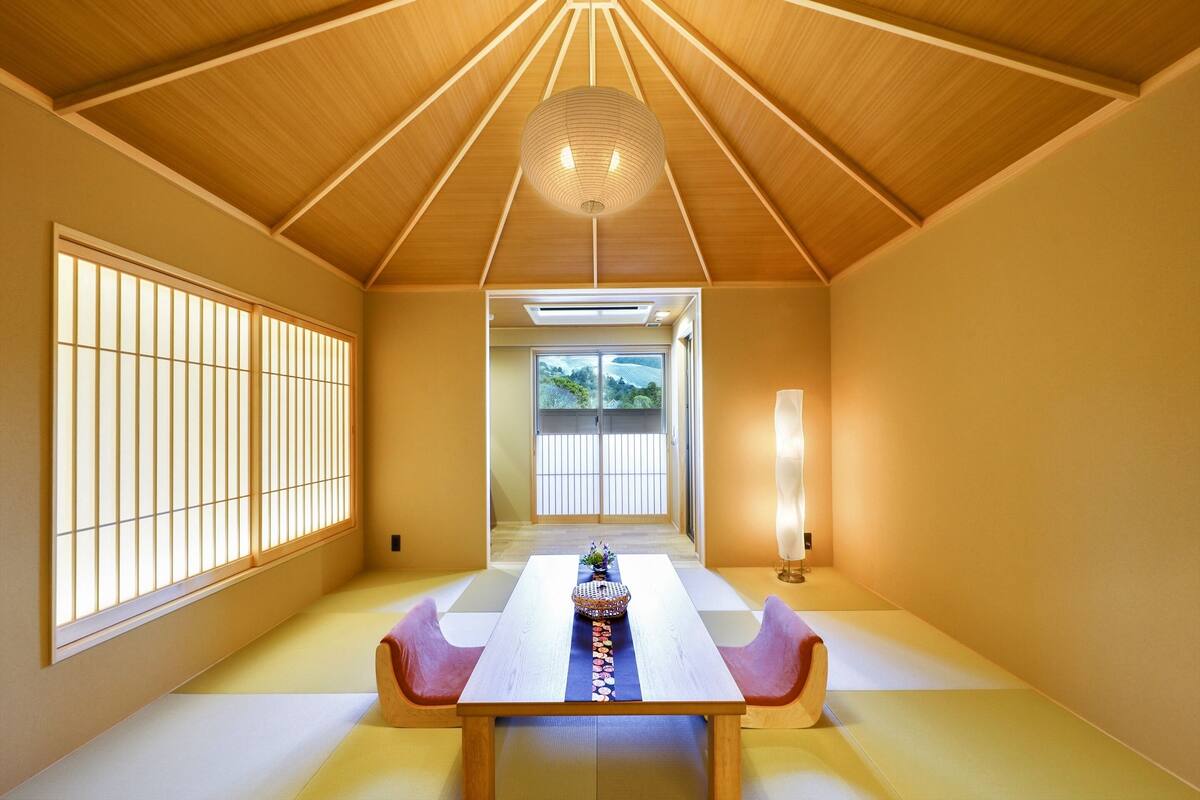 A traditional Japanese room with tatami flooring, a low wooden table, and shoji screens.