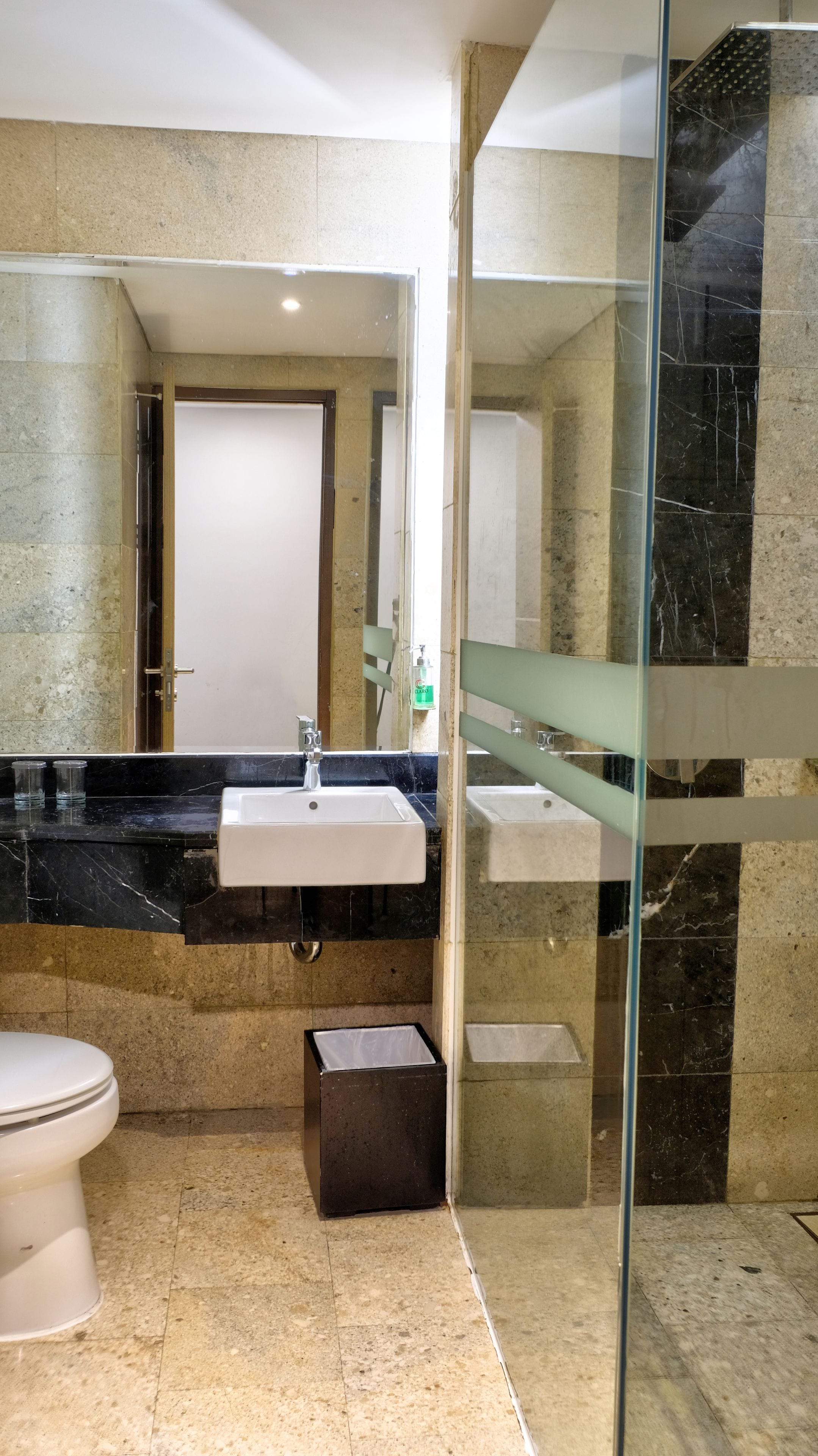 Une salle de bain moderne avec une douche à parois de verre, un lavabo blanc et des toilettes.