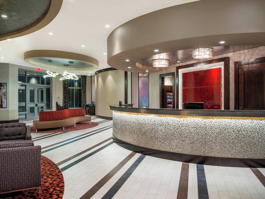 A lobby with a reception desk, seating area, and a large window.