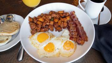 A breakfast plate with eggs, bacon, and hash browns.