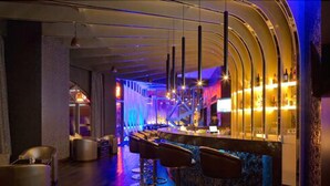 Eine Bar mit gewölbter Decke, Barhocker und einer Bar.