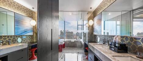 A modern bathroom with a large mirror, a vanity with a sink, and a red stool.