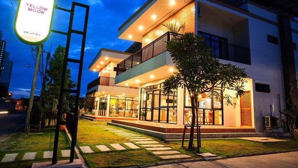 Un edificio moderno de dos pisos con una entrada bien iluminada y un cartel visible.