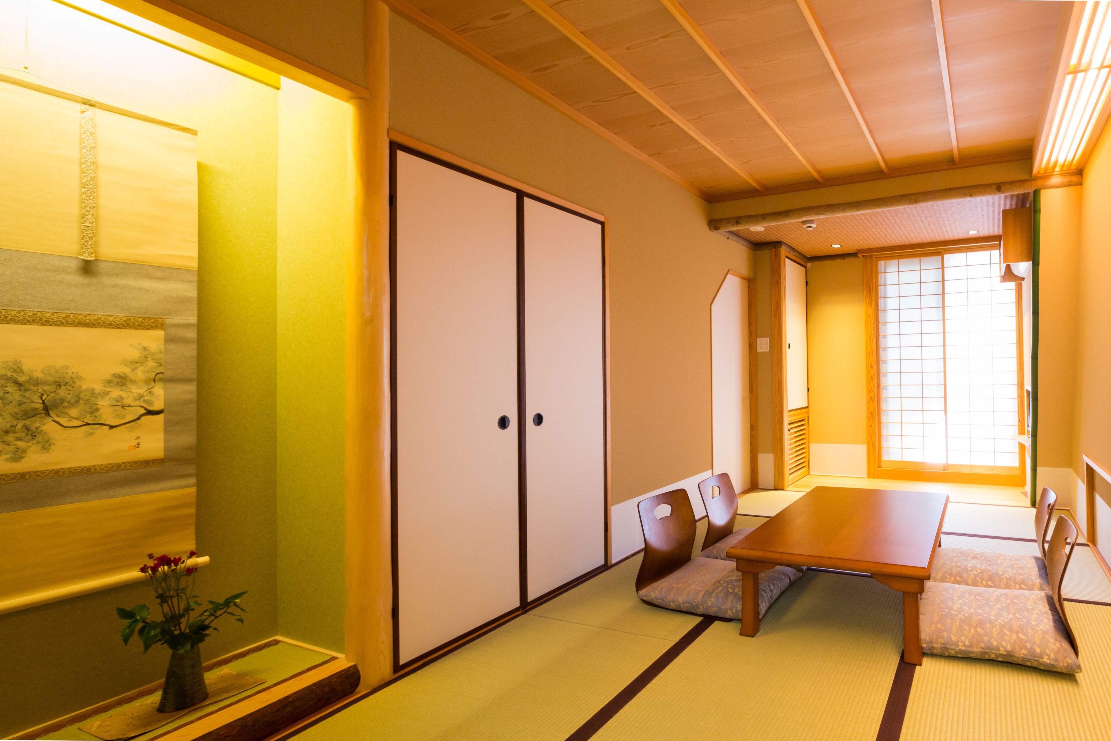 A traditional Japanese room with tatami flooring, a low table, and sliding doors.