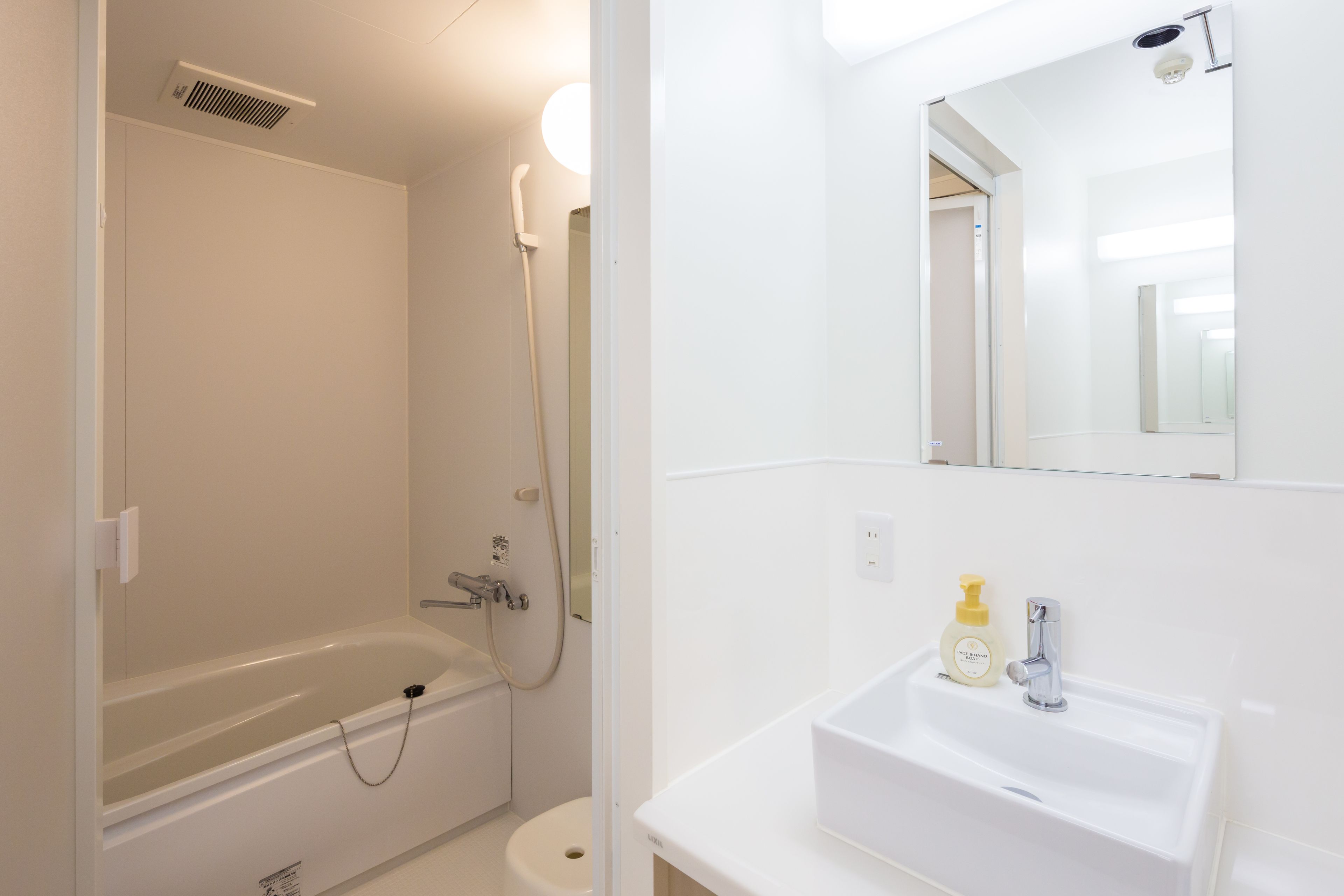 A bathroom with a bathtub, a toilet, a sink, and a mirror.