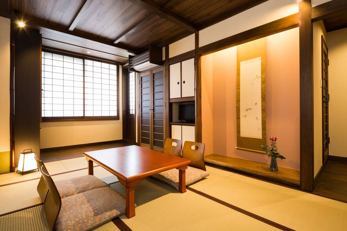 A traditional Japanese room with tatami flooring, a low wooden table, and sliding doors.