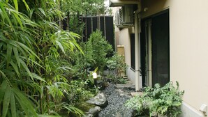 A garden with a water feature, rocks, and plants. - Matsubaya Ryokan (Kyoto)
