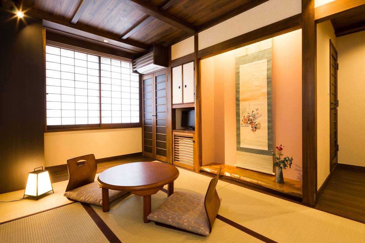 A traditional Japanese room with tatami flooring, a low wooden table, and sliding doors.