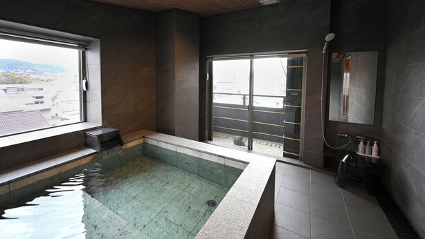 A modern bathroom with a glass-enclosed shower, a large window, and a view of the city. - Matsubaya Ryokan (Kyoto)