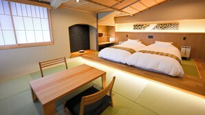 A traditional Japanese-style room with tatami flooring, a low wooden table, and a double bed with white bedding. - Matsubaya Ryokan (Kyoto)