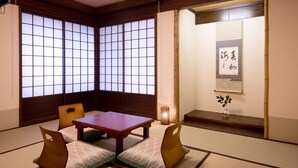 A traditional Japanese room with tatami flooring, a low wooden table, and cushions. - Matsubaya Ryokan (Kyoto)