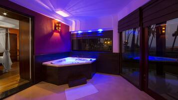 Relax in a spacious bathroom with a bathtub and enjoy a view of palm trees and the beach.