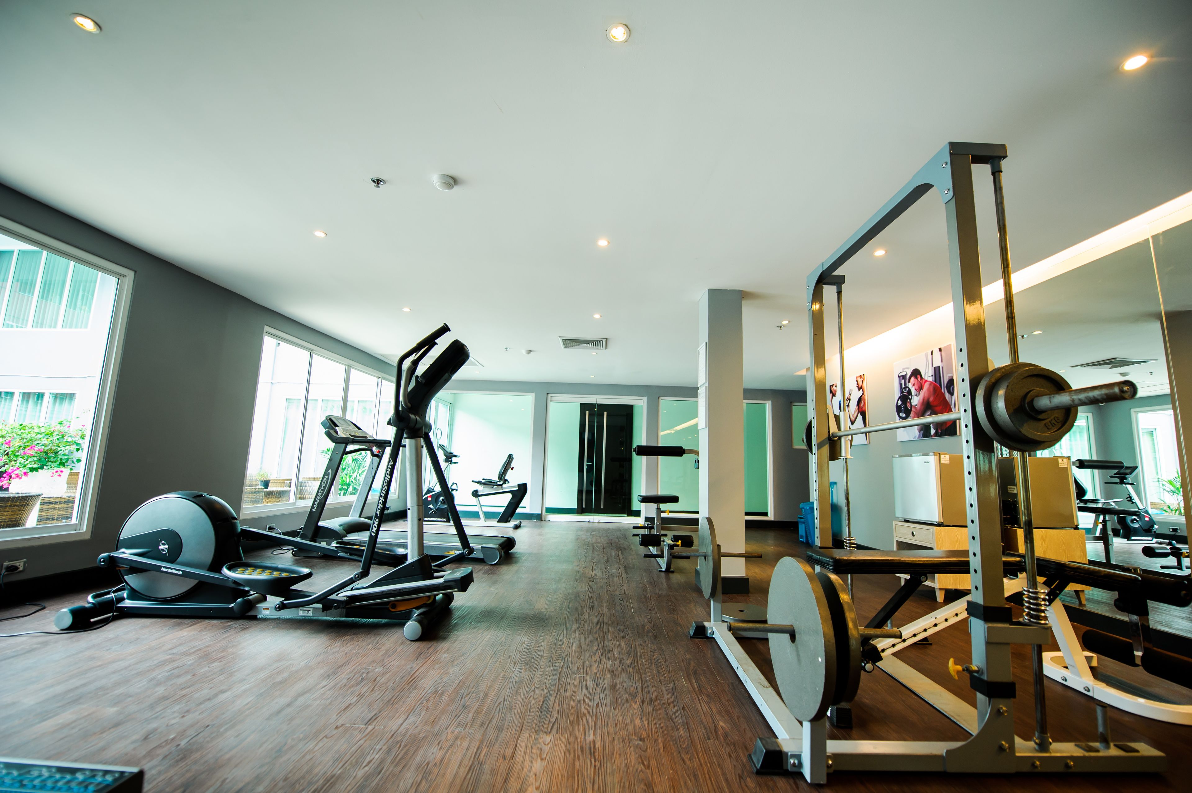 Un gimnasio con cintas de correr, elípticas y equipo de levantamiento de pesas.