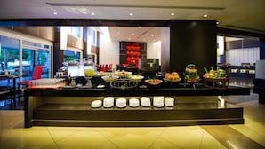 A buffet setup with various food items and plates arranged on a counter. - Hotel Selection Pattaya (Pattaya)