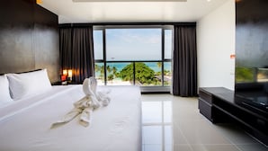 A modern hotel room with a large bed, a flat-screen TV, and a balcony with a view of the ocean. - Hotel Selection Pattaya (Pattaya)
