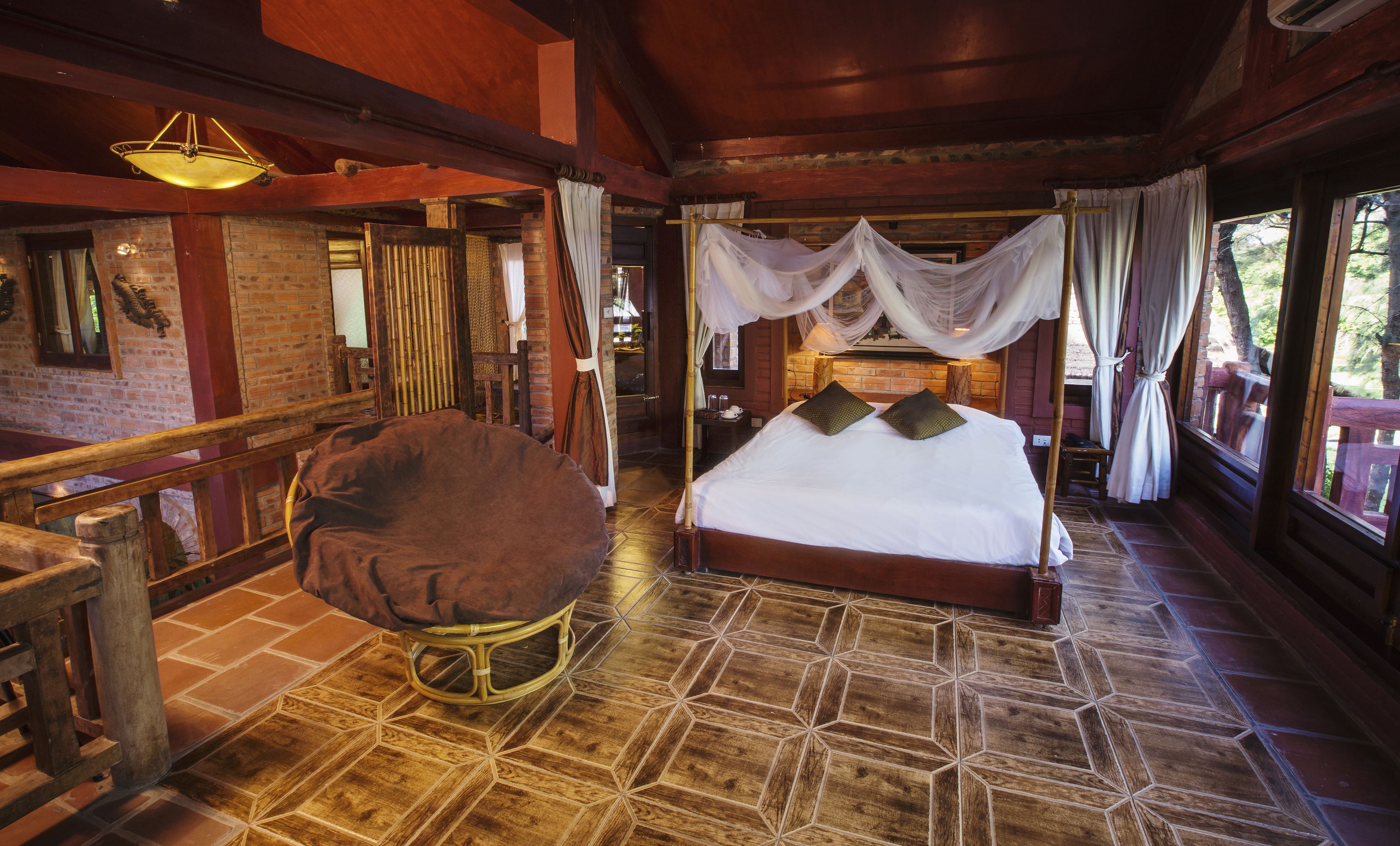 A spacious bedroom with a large bed, a wooden chair, and a canopy bed.