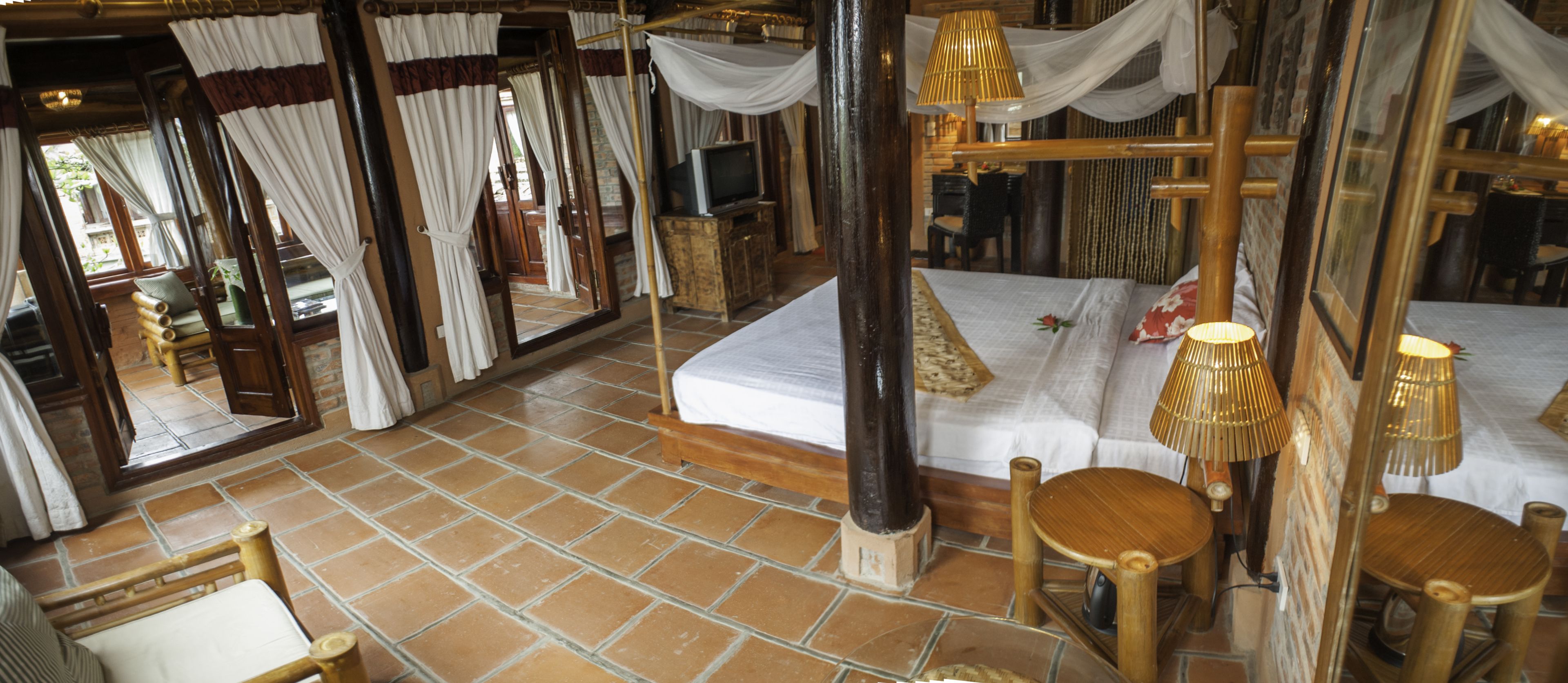 Una habitación con una cama, una silla de madera, una mesa y un espejo.