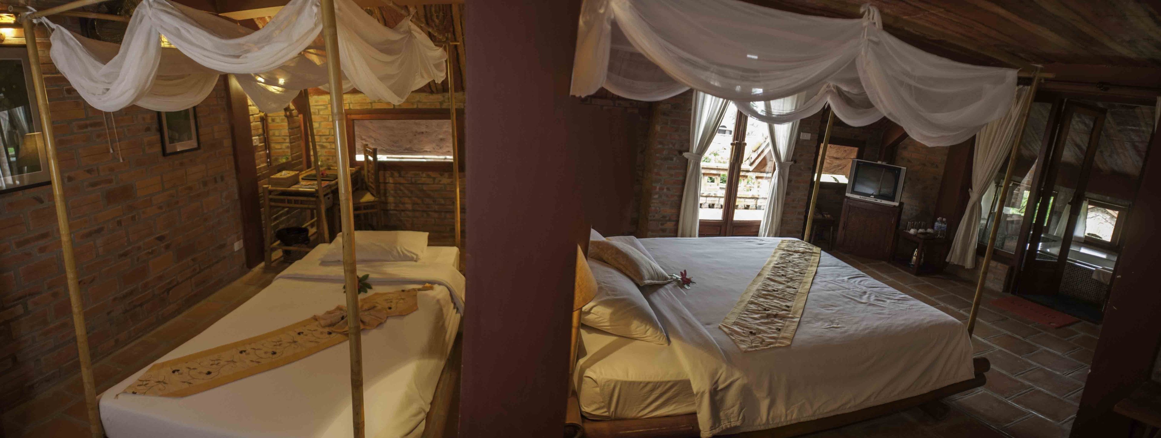 Una habitación con cama, televisión y pared de ladrillo.