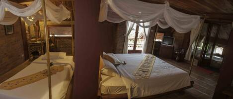 Una habitación con cama, televisión y pared de ladrillo.