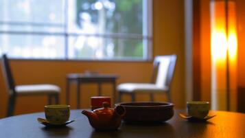 A round table with a teapot, two cups, and a bowl.