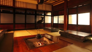 Una habitación japonesa tradicional con suelo de tatami, una mesa de madera baja y una chimenea.