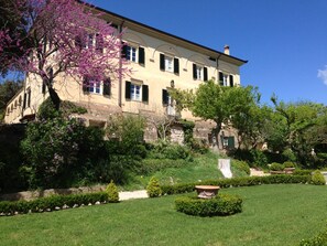 A large, historic building with multiple windows and a well-maintained garden in front. - Wine Resort La Ghirlanda (Gualdo Cattaneo)
