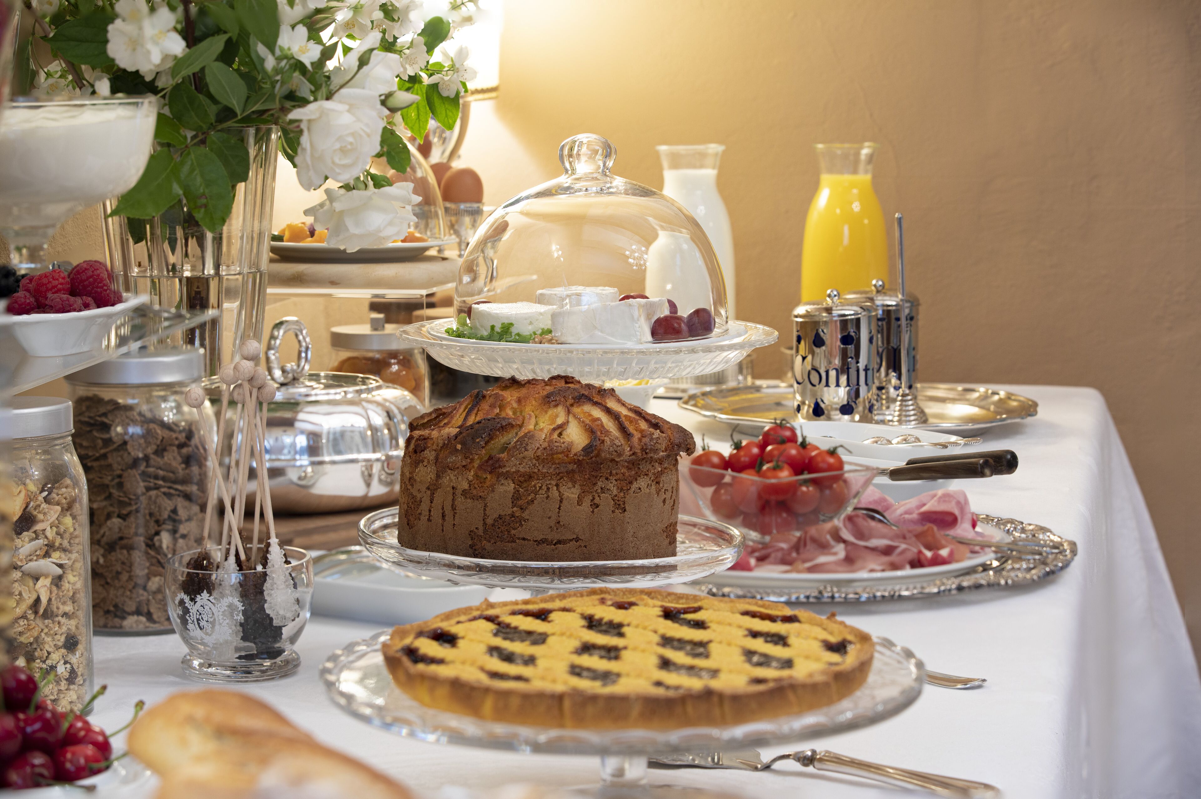 A breakfast buffet with various food items, including a cake, fruit, and pastries.