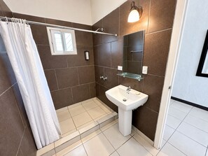 Une salle de bain moderne avec une douche, un lavabo et un miroir.