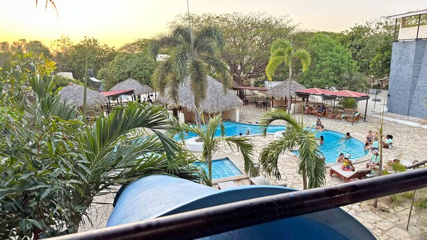 Ein Poolbereich mit mehreren Pools, Liegestühlen und Sonnenschirmen.