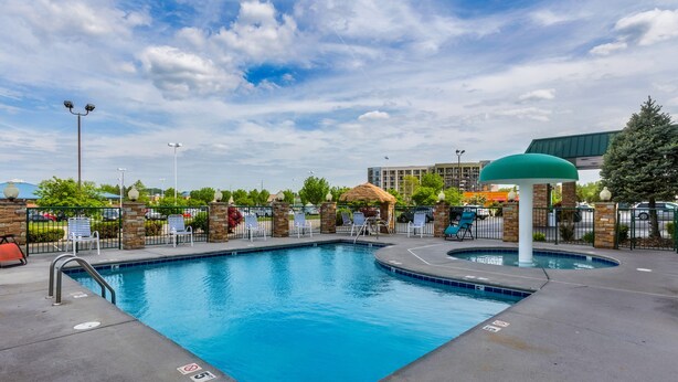 A swimming pool with a diving board, lounge chairs, and a covered seating area. - Park Grove Inn (Pigeon Forge)