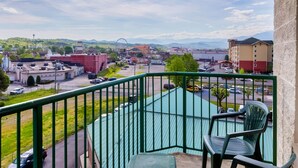 A balcony with a view of a town, including a Ferris wheel and a body of water. - Park Grove Inn (Pigeon Forge)