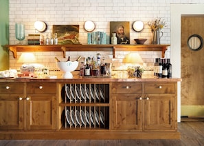 A wooden bar area with a wine rack, bottles, and decorative items.