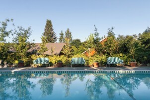 Una piscina al aire libre, sombrillas, tumbonas