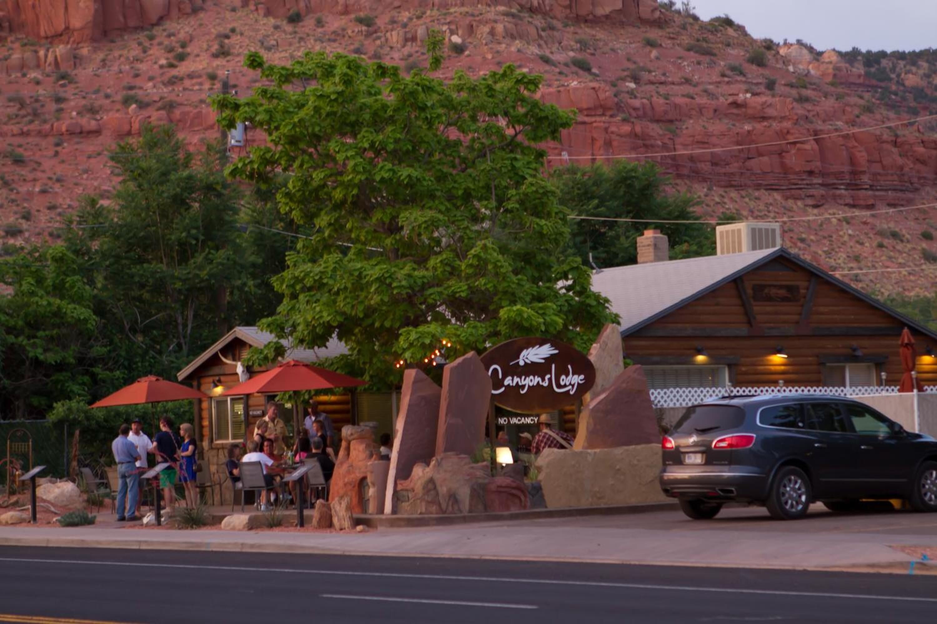 Un restaurante llamado "Canyons Lodge" con terraza al aire libre y montañas al fondo.