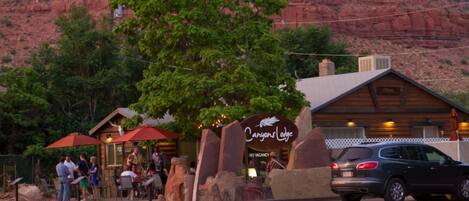 A restaurant named "Canyons Lodge" with outdoor seating and a mountainous backdrop.