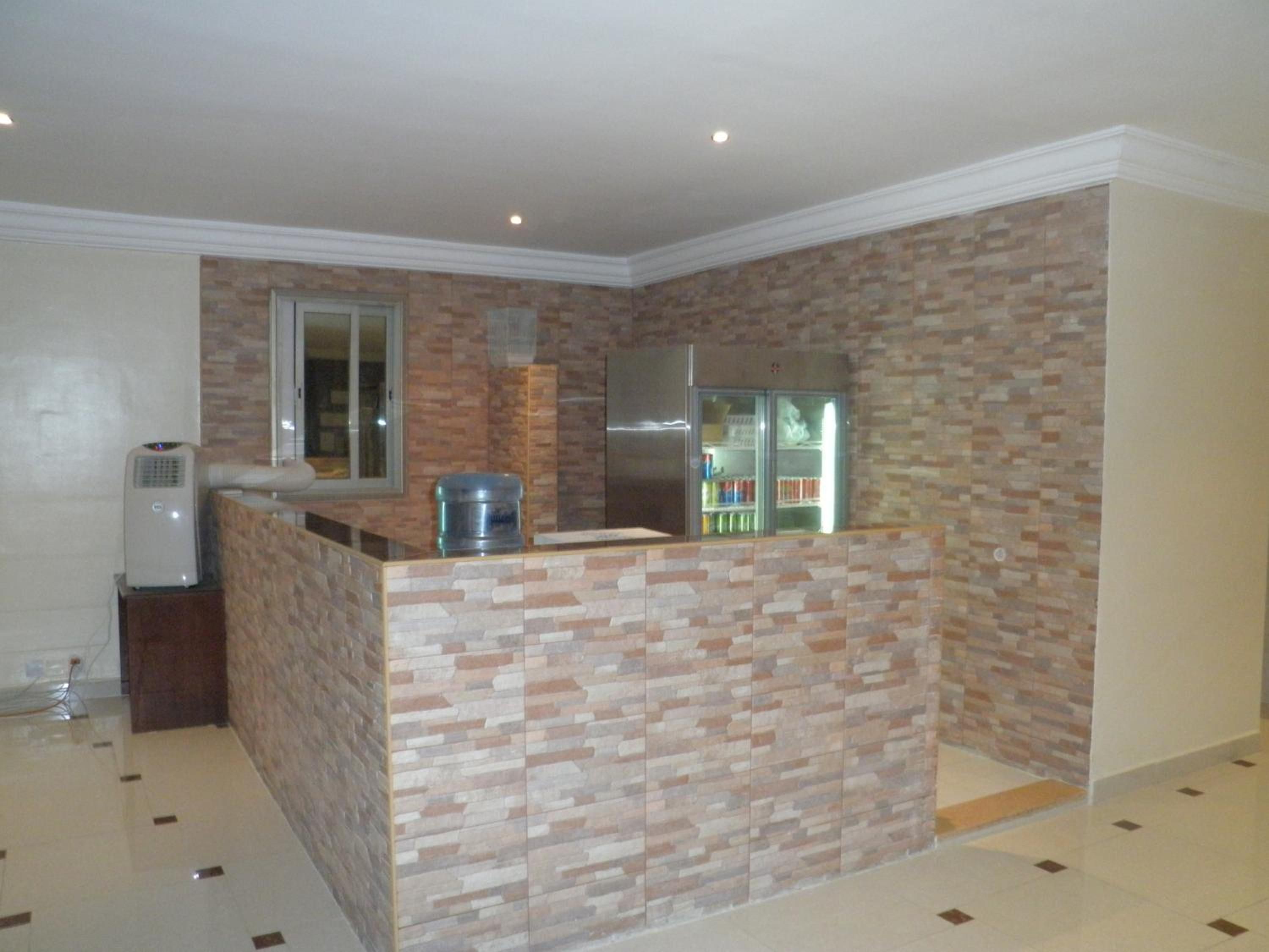 A kitchen with a brick backsplash, a refrigerator, and a water dispenser.