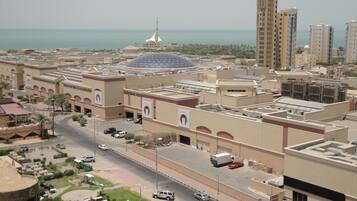 A modern urban area with a prominent dome structure, high-rise buildings, and a coastal view.