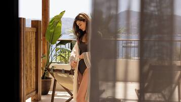 Terrace Seaview Suite | Ylelliset vuodevaatteet, minibaari, tallelokero huoneessa, työpöytä