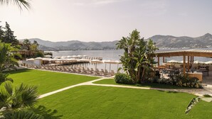 A coastal resort with a grassy lawn, outdoor seating, and a view of the sea and mountains. - Avantgarde Refined Yalıkavak (Bodrum)