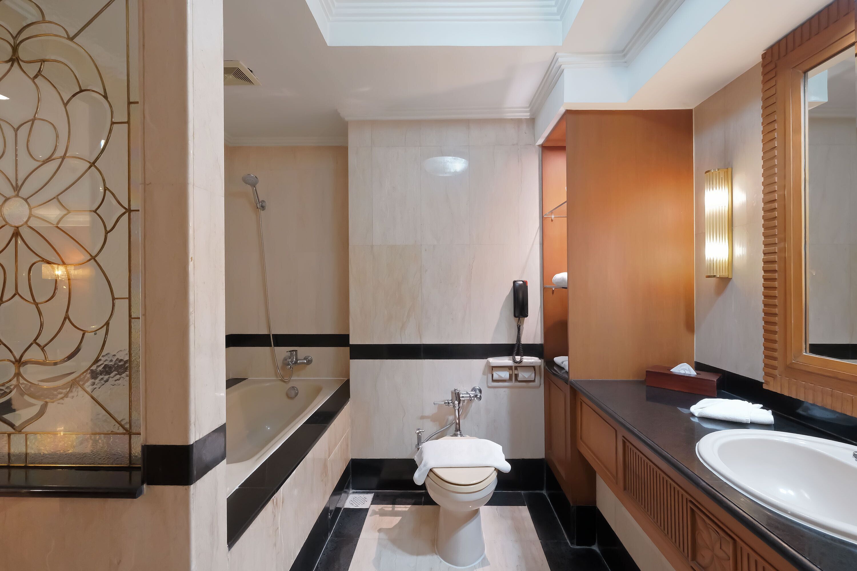 A modern bathroom with a bathtub, toilet, and large sink.