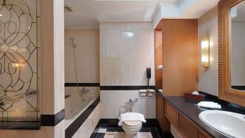 A modern bathroom with a bathtub, toilet, and large sink.