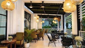 A restaurant with wicker pendant lights, indoor plants, and a mix of wooden and metal chairs. - Sunlake Waterfront Resort and Convention (Jakarta)