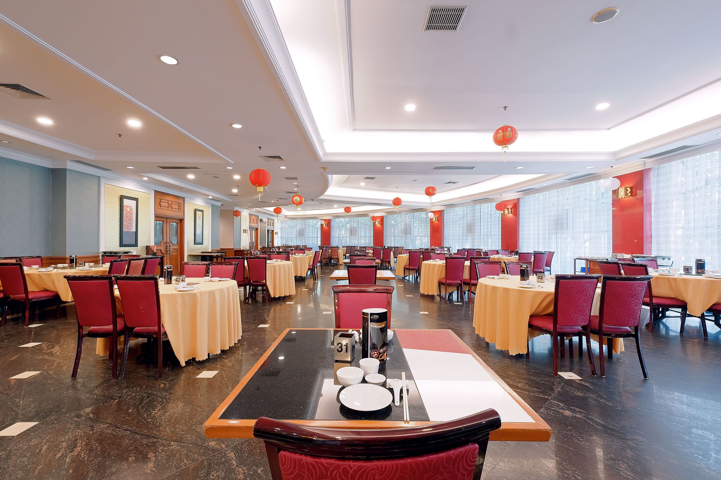 A spacious dining area with multiple tables and chairs, arranged in rows.
