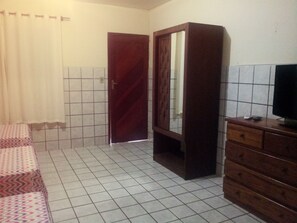 A room with a bed, a wooden wardrobe, a television on a dresser, and a tiled floor. - Dandão Pousada (Fernando de Noronha)