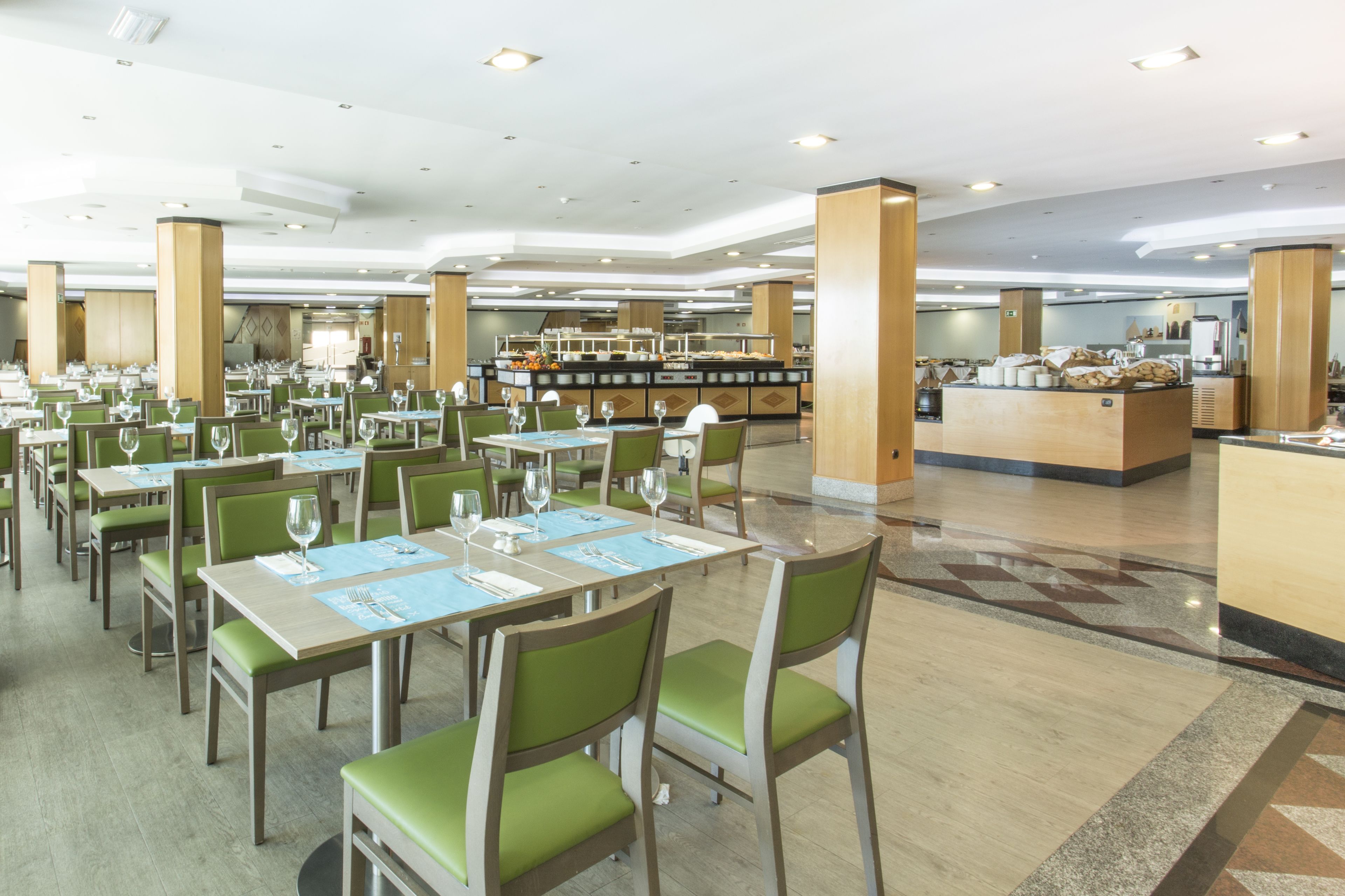 A spacious dining area with multiple tables and chairs, a buffet station, and a clean, modern interior.