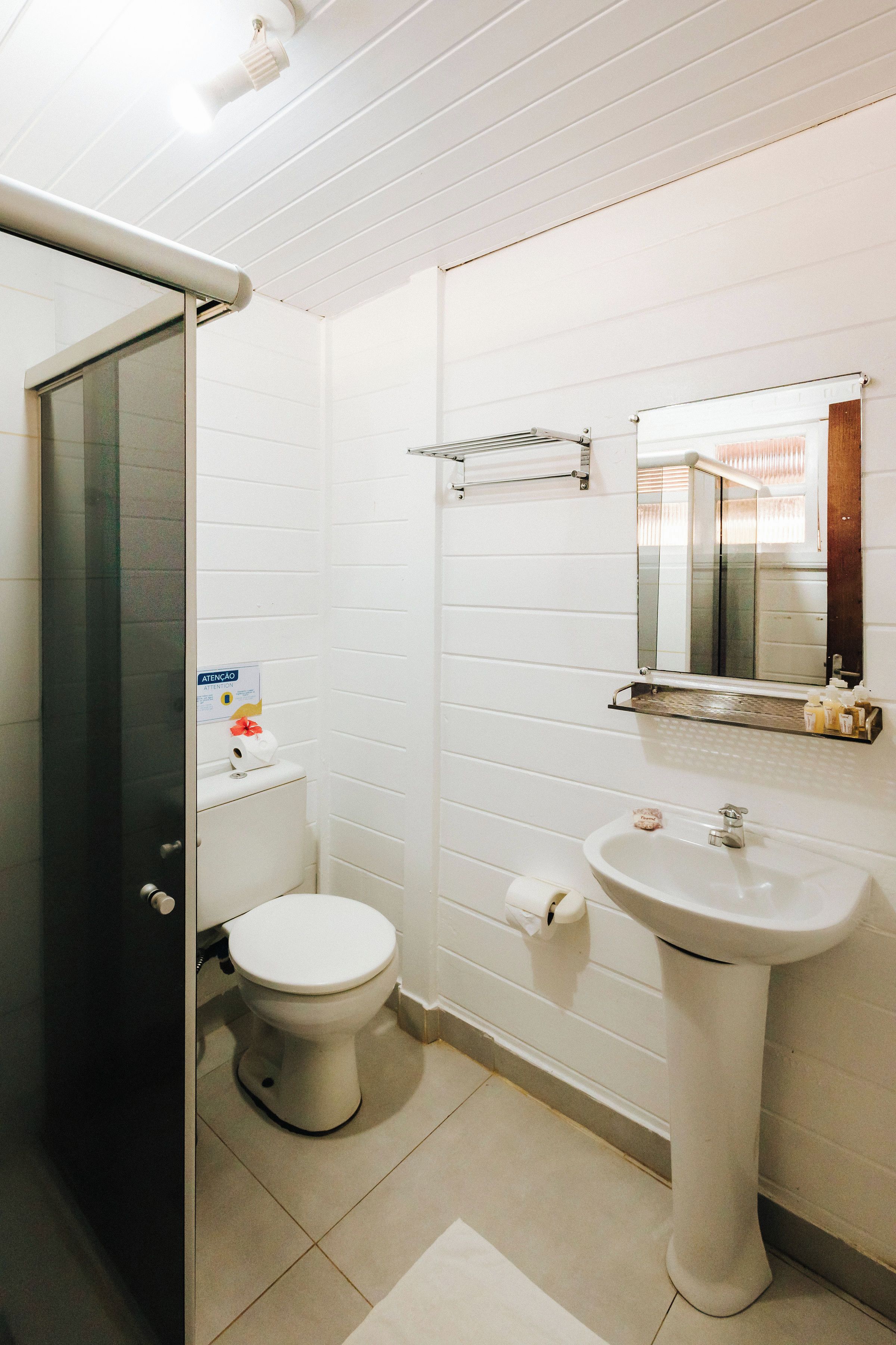 A bathroom with a toilet, sink, and mirror.