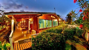 A wooden building with a covered porch and a glass facade. - Pousada Lenda das Águas (Fernando de Noronha)