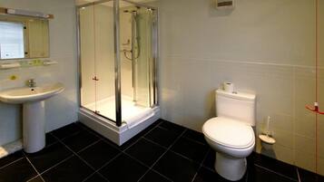 A bathroom with a glass-enclosed shower, a sink, and a toilet.