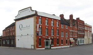 A historic building with a sign for 'Queens Hotel & Conference Centre' and 'Three Queens Hotel'. - Three Queens Hotel (Burton on Trent)