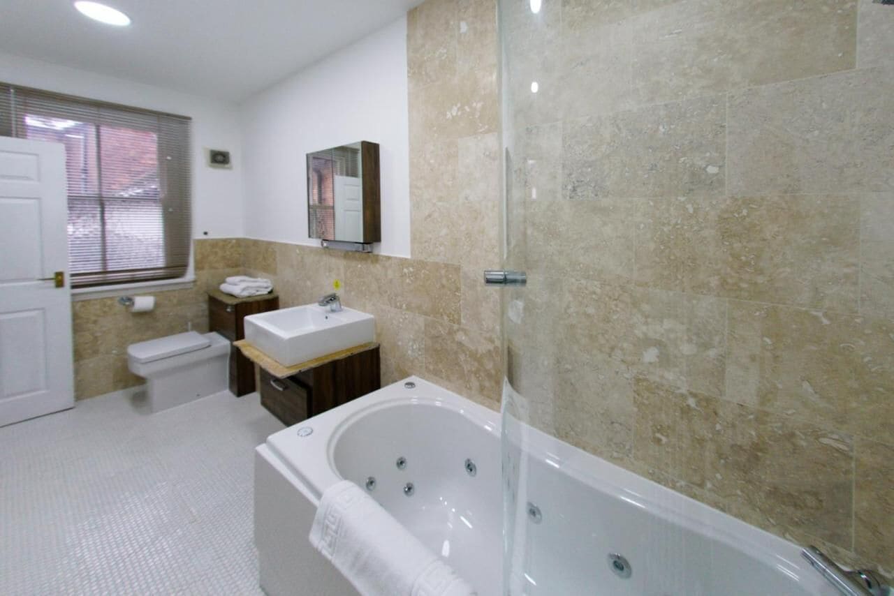 A modern bathroom with a bathtub, a sink, and a toilet.